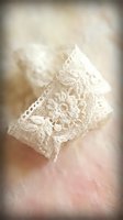 Delicate white lace fabric with intricate floral embroidery pattern floating softly against neutral background for wedding and romantic design projects.
