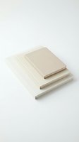 Stack of three blank notebooks with neutral beige covers arranged on white background for minimalist stationery and office supplies mockup designs.