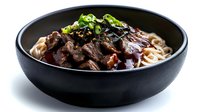 Korean beef bulgogi with noodles in black bowl garnished with fresh scallions and sesame seeds for Asian cuisine menu and restaurant marketing.