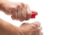 Close-up of male hands applying red nail polish on white background, isolated for design use on apparel and promotional materials.