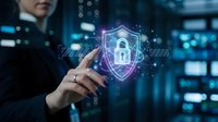Businessman touching digital security shield with padlock icon in modern data center representing cybersecurity and data protection technology.