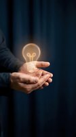 Businessman holding glowing light bulb in cupped hands against dark blue background, symbolizing innovation, creativity, and new ideas for business concepts and entrepreneurship.
