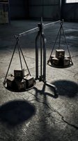 Vintage brass balance scale with wooden blocks on concrete floor in dramatic lighting for justice and law concepts.