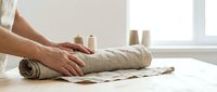 Professional baker hands kneading fresh bread dough on floured surface in bright kitchen workspace for artisan baking and homemade cooking projects.