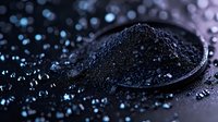 Macro shot of black caviar on dark background with water drops and blue light reflection creating luxury food atmosphere and dramatic mood.