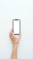 Hand holding smartphone with blank white screen mockup on light background for app presentation and digital marketing materials.