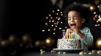 Joyful African American child laughing at birthday cake with lit candles against dark background with bokeh lights and confetti. Celebration moment.