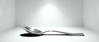 Melting silver spoon on white surface, surreal conceptual art depicting transformation and fluidity in monochrome style.