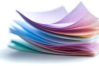 Stack of colorful paper sheets with curved edges creating soft waves and gradient effect from purple to blue, pink and turquoise on white background.