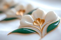 Delicate white paper flowers with golden centers and emerald leaves create soft dimensional artwork against white background, showcasing elegant craftsmanship and design.
