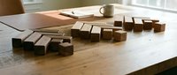 Wooden building blocks arranged in descending steps on rustic table surface creating architectural pattern for educational toys and creative play activities.