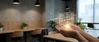 Hand holding glowing digital network sphere with connected dots in modern office workspace representing technology innovation and connectivity solutions.