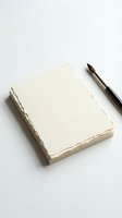 Handmade paper notebook with deckled edges and fountain pen on white background for stationery and writing projects.