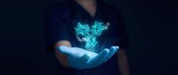 Close-up of a person's hand holding a glowing turquoise holographic butterfly symbol against dark background, representing technology, innovation, and digital transformation concepts.