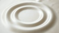 Concentric circular ripples create smooth, flowing waves in creamy white liquid, suggesting motion and tranquility for wellness and spa design projects.