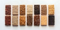 Variety of brown rice types arranged in neat rows showing different textures and colors of whole grain cereals on white background, top view composition.