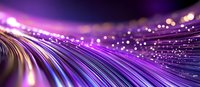 Glowing purple fiber optic cables with bokeh light effects create futuristic technology background with motion blur and shallow depth of field.