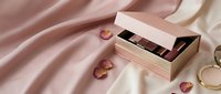 Luxury rose gold makeup palette with eyeshadows in elegant packaging on silk fabric with decorative elements for beauty and cosmetics branding.