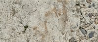 Weathered concrete surface with cracks, stains, and scattered gravel debris, suitable for backgrounds, textures, and industrial design projects.