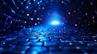 Futuristic blue technology background with glowing light and bokeh effect on textured surface creates depth and perspective for digital concepts.