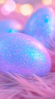 Glittery Easter eggs in pastel blue and pink tones with sparkly decoration resting on soft feathers against dreamy bokeh background, creating magical holiday atmosphere.