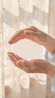 Elderly hands forming protective gesture in soft natural light, symbolizing care, security and guardianship for insurance and healthcare concepts.