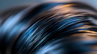 Macro abstract background with blurred blue and gold feathers or hair strands creating dynamic curved lines and patterns. Artistic photography for design projects.