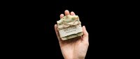 Caucasian hand holding wrapped gift box with gold ribbon and white label on transparent background, ready for design use in t-shirts, clipart, stickers, print-on-demand products, and sublimation projects.