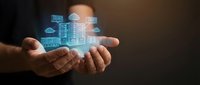 Businessman holding glowing holographic smart city building with digital technology icons, representing urban development, IoT infrastructure and innovation solutions.