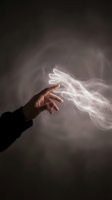 Hand releasing glowing white energy or magical light against dark background, symbolizing power, spirituality, or supernatural force for creative design projects.