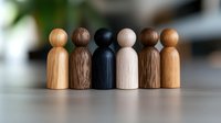 Wooden figures standing together symbolizing diversity, unity and teamwork concept. Natural wood tones represent different races and ethnicities in minimalist style.