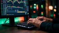 Professional trader analyzing financial data on computer with colorful charts and graphs displayed on screen during evening trading session.