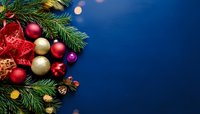 Christmas decorations with red and gold ornaments, pine branches, and festive ribbon against deep blue background with copy space.