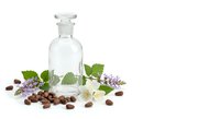 Glass bottle with essential oils, coffee beans, and fresh herbs on white background for aromatherapy and natural wellness products.