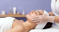 Young woman receiving relaxing facial massage treatment at luxury spa with therapist hands on face for skincare wellness and beauty rejuvenation.