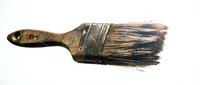 Worn paintbrush with natural bristles and wooden handle isolated on white background, ready for design use in art, craft, and DIY projects.
