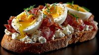 Gourmet breakfast toast with soft boiled egg, crispy bacon, crumbled feta cheese, and fresh herbs on rustic bread against dark background.