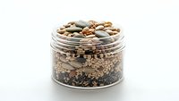 Glass jar filled with assorted legumes beans lentils chickpeas quinoa healthy protein pantry staples isolated on white background for cooking recipes.