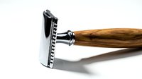 Classic safety razor with polished chrome head and natural wood handle on white background, showcasing premium grooming tool for men's shaving routine.