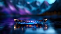 Elegant crystal bowl with colorful reflections on dark surface against blurred mountain landscape background for luxury product display and presentation.