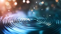 Mesmerizing water ripples with concentric circles on dark surface against blurred bokeh lights in blue and orange tones creating tranquil atmospheric background.