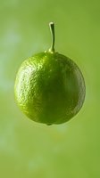 Fresh whole lime with stem against blurred green background, macro shot showing textured citrus skin with water droplet, suitable for food and beverage marketing.