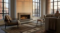 Modern living room with fireplace, comfortable seating, and large windows overlooking urban skyline. Contemporary interior design for home decor and lifestyle publications.