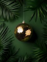 Golden disco ball hanging against dark green background with tropical palm leaves framing the composition. Perfect for party or event promotion.
