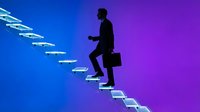 Silhouette of a male professional in business attire climbing illuminated stairs against a blue to purple gradient background, symbolizing career growth and success.