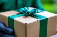 Elegant gift box with turquoise satin ribbon and bow on natural kraft paper, holiday present packaging for celebrations and special occasions.