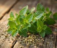 Fresh oregano herb leaves with dried seasoning on rustic wooden background for culinary cooking and natural ingredient recipes.