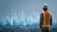 Construction worker in safety vest and helmet looking at futuristic city skyline with digital overlay, representing urban development and smart city technology.