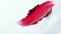 Red lipstick smear stroke isolated on white background for cosmetic makeup beauty product advertising and fashion design projects.