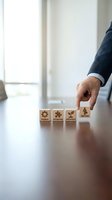 Businessman hand selecting wooden blocks with business icons representing training, integration, development and employee growth strategy.